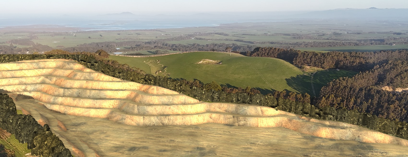 The same view with a concept of the proposed benched pit cut into the ridge, edged by a mature belt of screen trees.
